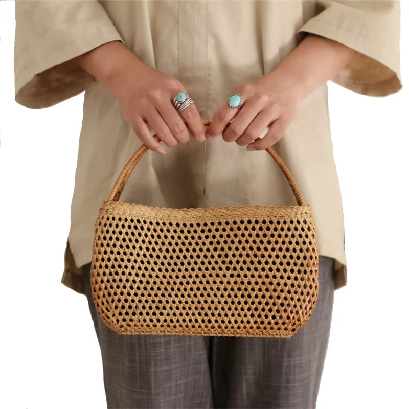 Sac Effet Osier Élégant Petit Format, de couleur marron avec une anse, porté par une femme, sur un fond blanc.