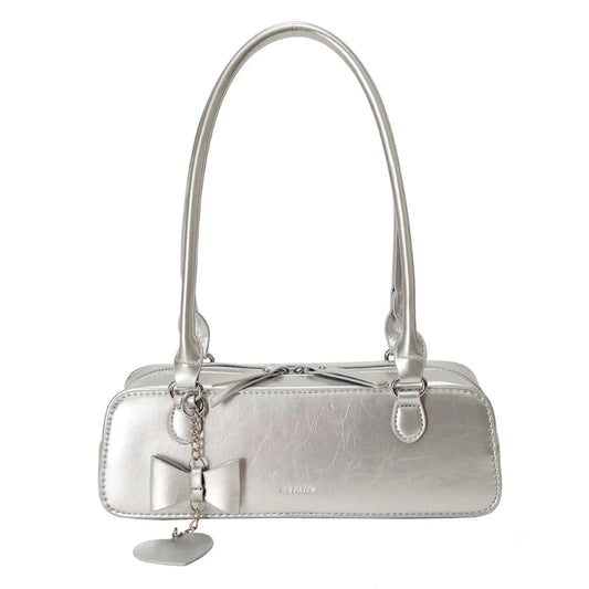 Sac à Main Baguette Simili avec Pendentif, de couleur argentée, fermeture à zipper, sur un fond blanc.
