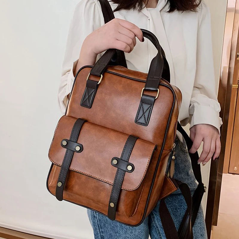 Sac Cartable Femme Multipoches Marron, avec anses noires, dans la main d'une femme.