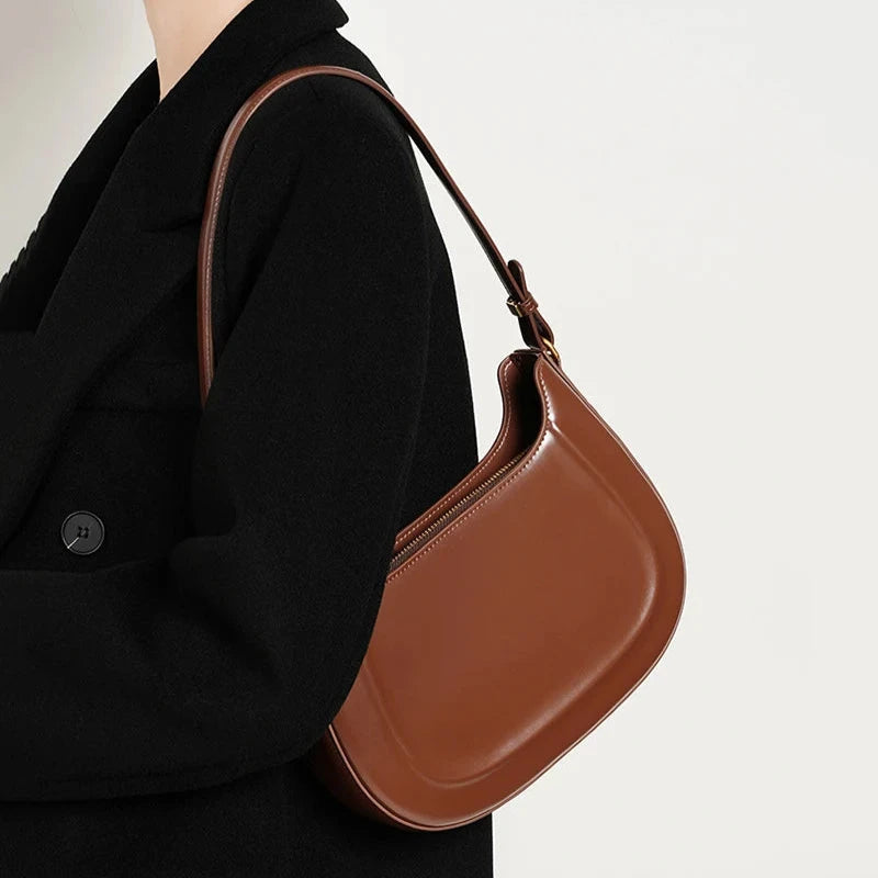 Sac à Main Baguette Design Épuré Marron, avec bandoulière, porté sur l'épaule d'une femme avec un manteau noir.