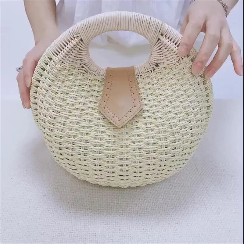 Sac Effet Osier Design Rond Élégant, de couleur beige, avec des mains de femme dessus.