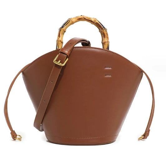 Sac à Main Seau avec Poignée en Bambou, de couleur camel et sur fond blanc.