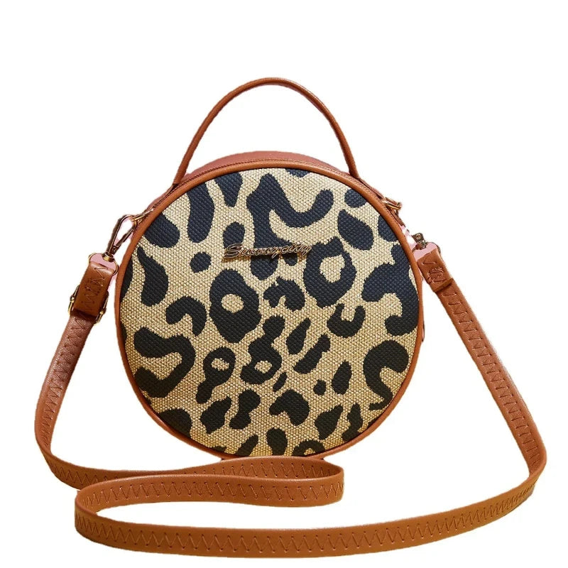 Sac à Main Rond à Bandoulière Motif Léopard, de couleur marron, sur un fond blanc.