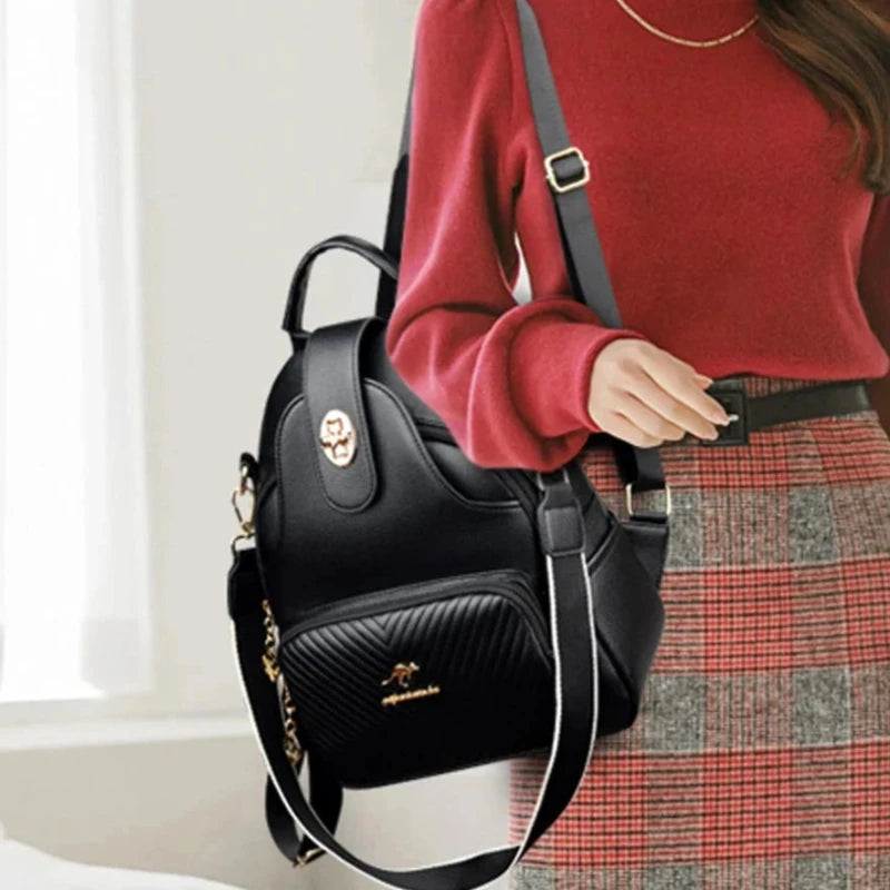 Sac à Main et à Dos Femme Robuste et Multipoches, de couleur noir, avec bretelles et bandoulière, porté par une femme avec un pull rouge, sur son épaule.