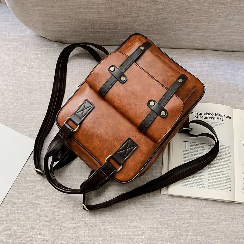 Sac Cartable Femme Multipoches Marron, posé à plat sur un canapé, vue de dos avec les sangles étalées. - Camel - Noir - Marron