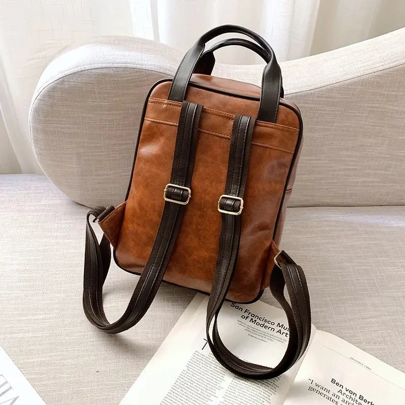 Sac Cartable Femme Multipoches Marron, vue de dos posé sur un fauteuil, sangles à dos déployées. - Camel - Noir - Marron