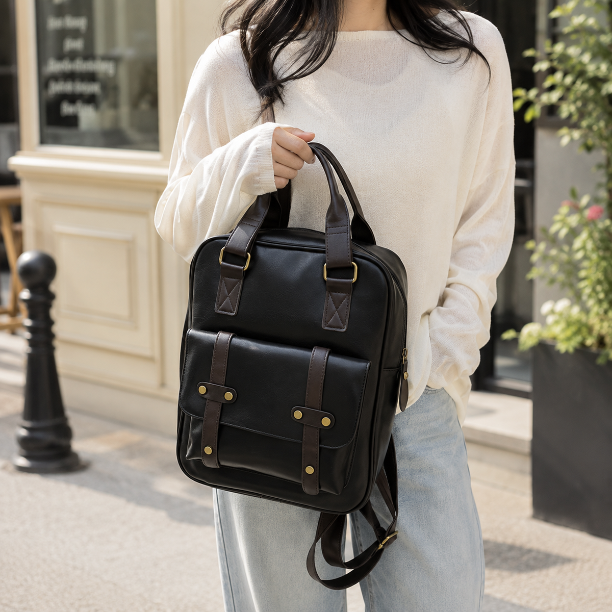Sac Cartable Femme Multipoches en coloris noir, porté à la main par une femme dans la rue. - Camel - Noir - Marron
