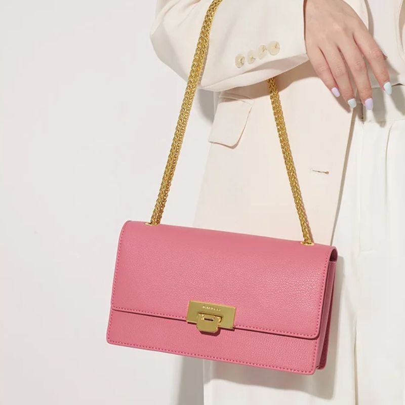 Sac à Main Luxe en Cuir Rose pour Femme porté à la main par une femme